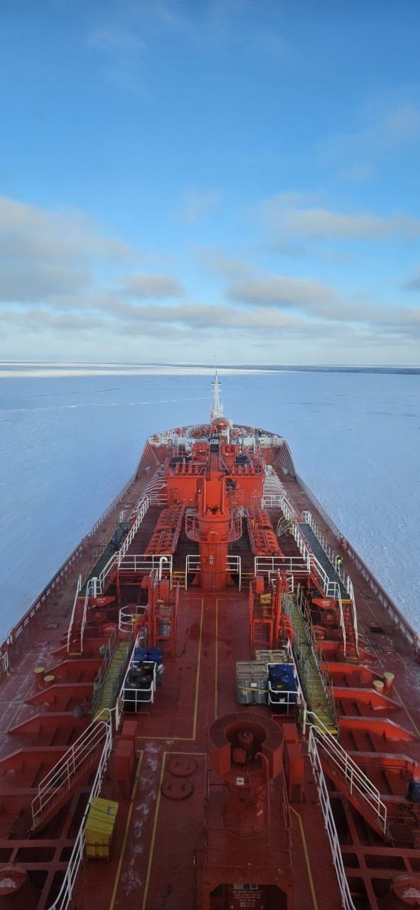 Tanker bow breaking through ice under clear sky